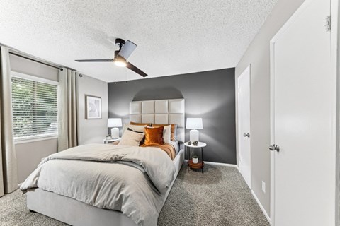 a bedroom with a bed and a ceiling fan